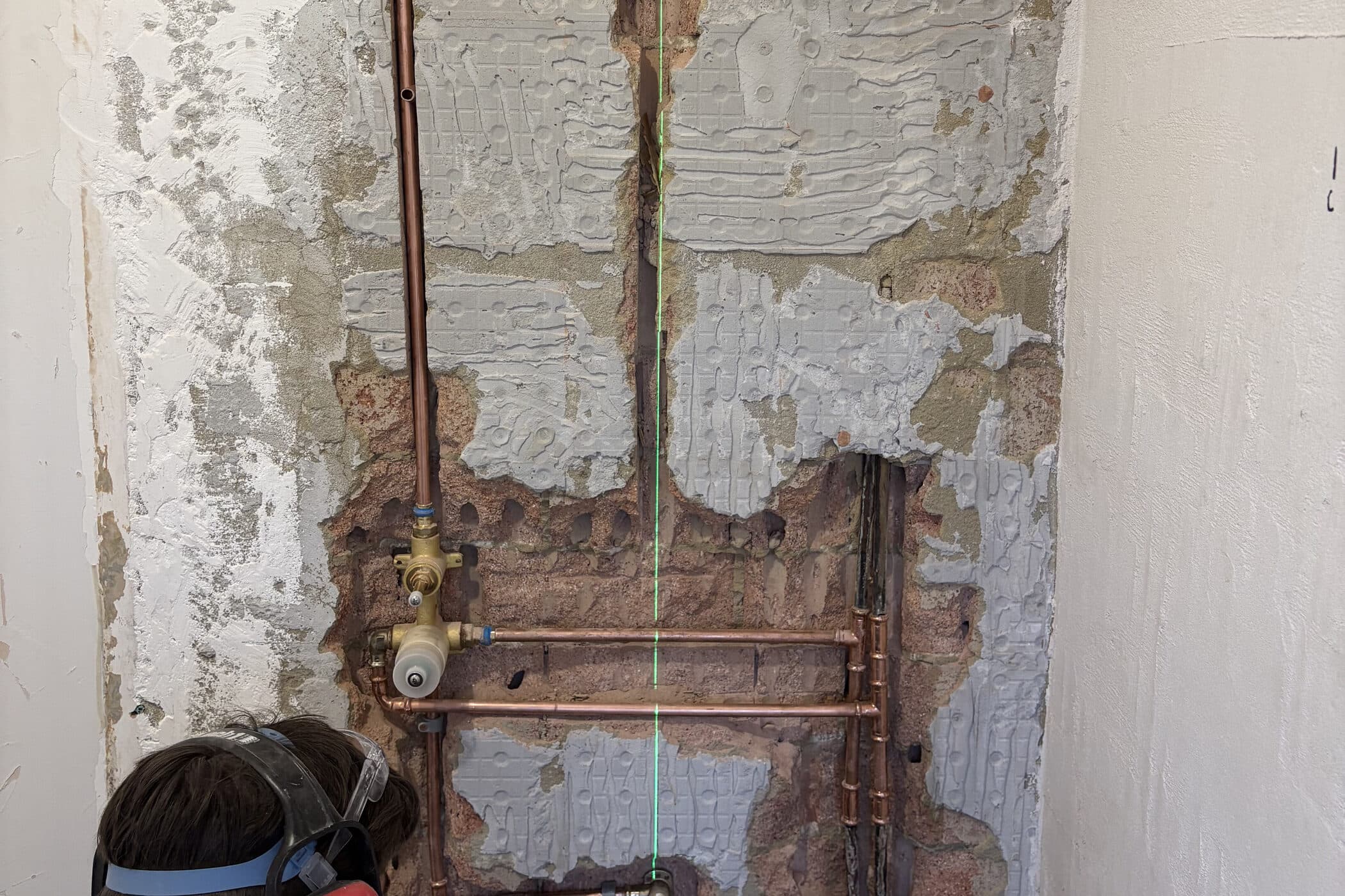 Copper hot and cold set out across an open bathroom wall during a renovation rough-in