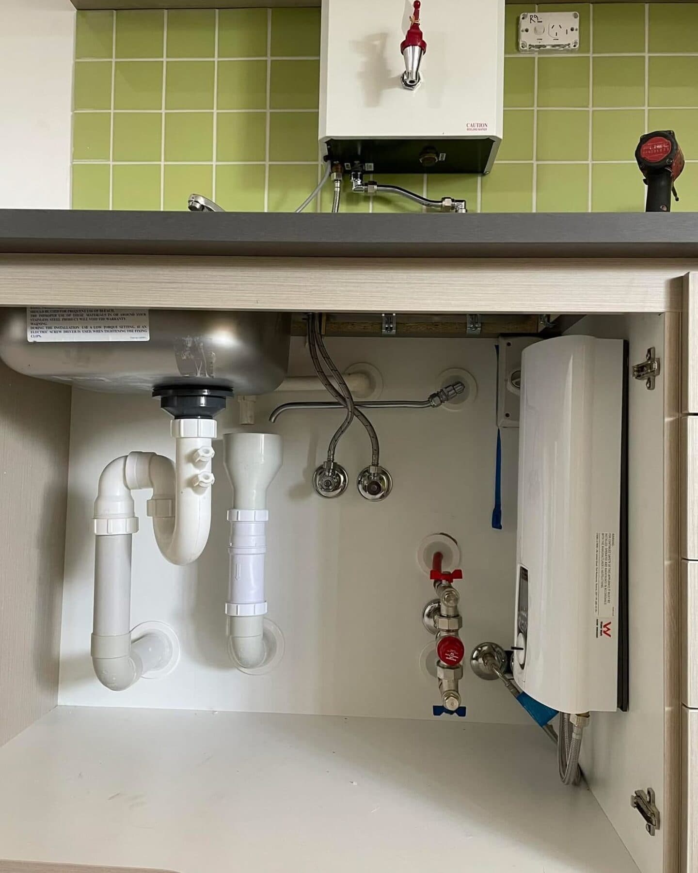 A finished under-sink installation, pipework and isolation valves neatly run